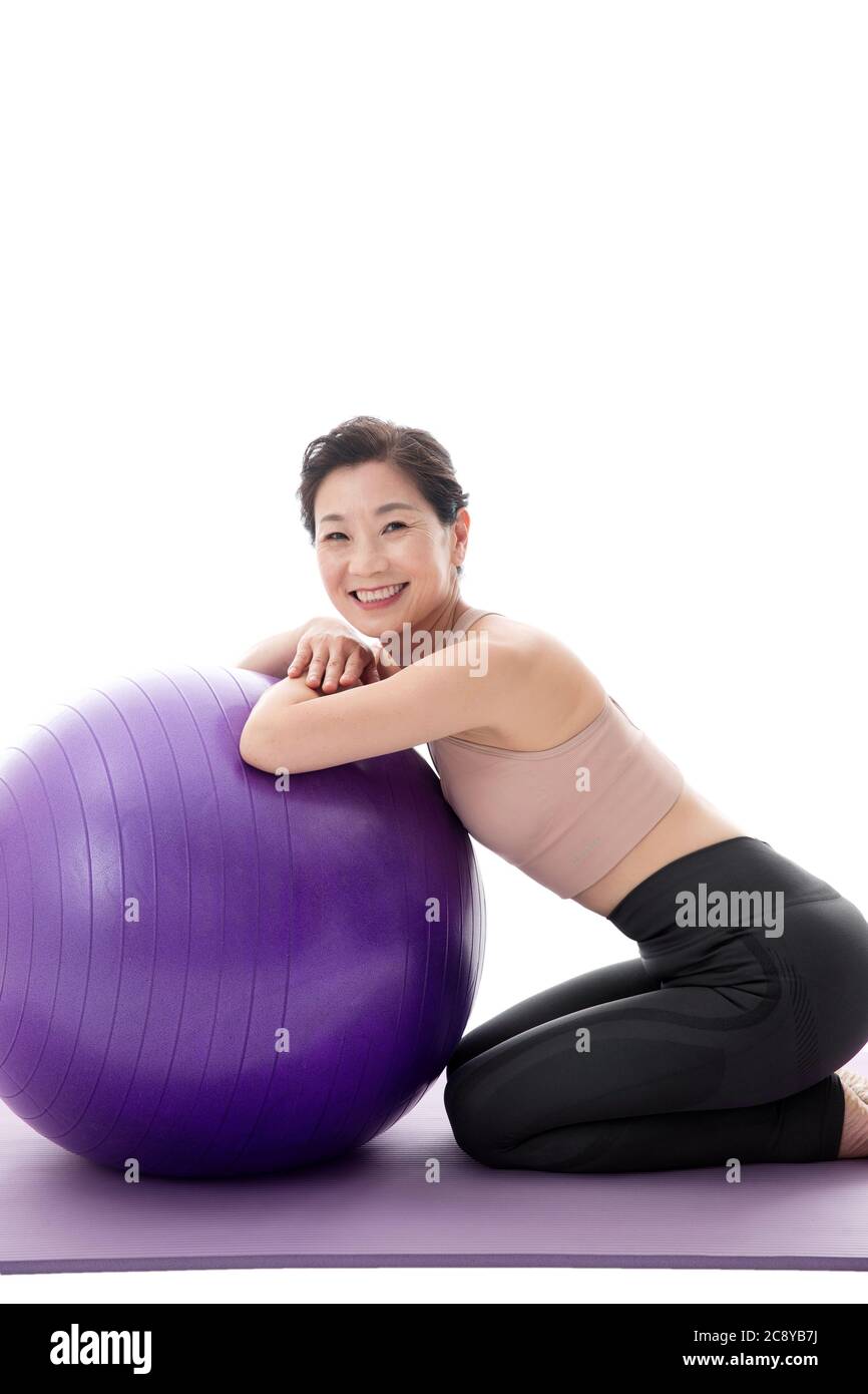 Middle-aged women lie prone on the yoga ball Stock Photo