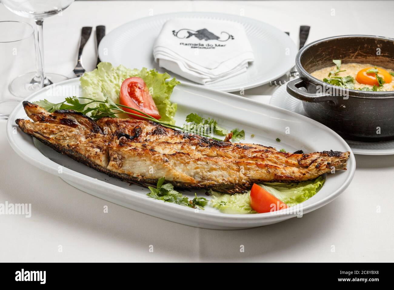 Fried fish near slices of letus on a white plate Stock Photo