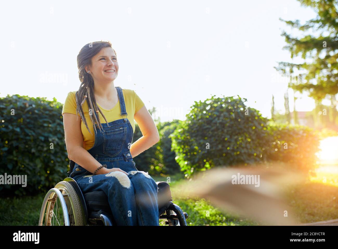 beautiful disabled girl looking up, looking at the bright side of life, woman gets pleasure from the beauty of nature, landscape. copy space Stock Photo