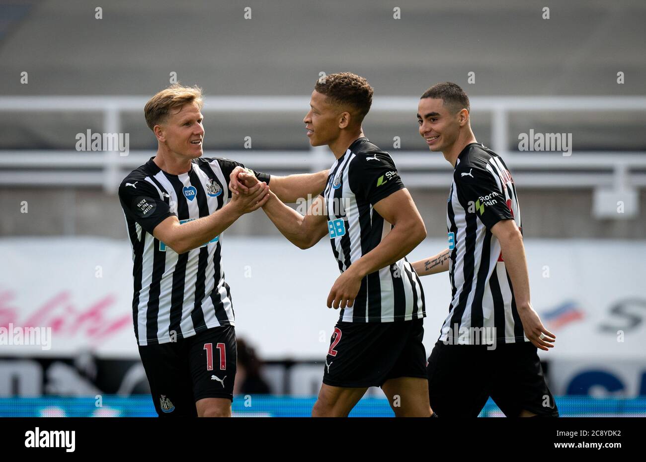 Newcastle, UK. 26th July, 2020. Matt Ritchie (11) congratulates Dwight Gayle of Newcastle United on his goal as Miguel Almir-n of Newcastle United looks on during the Premier League match between Newcastle United and Liverpool Football Stadiums around remain empty due to the Covid-19 Pandemic as Government social distancing laws prohibit supporters inside venues resulting in all fixtures being played behind closed doors until further notice at St. James's Park, Newcastle, England on 26 July 2020. Photo by Andy Rowland. Credit: PRiME Media Images/Alamy Live News Stock Photo