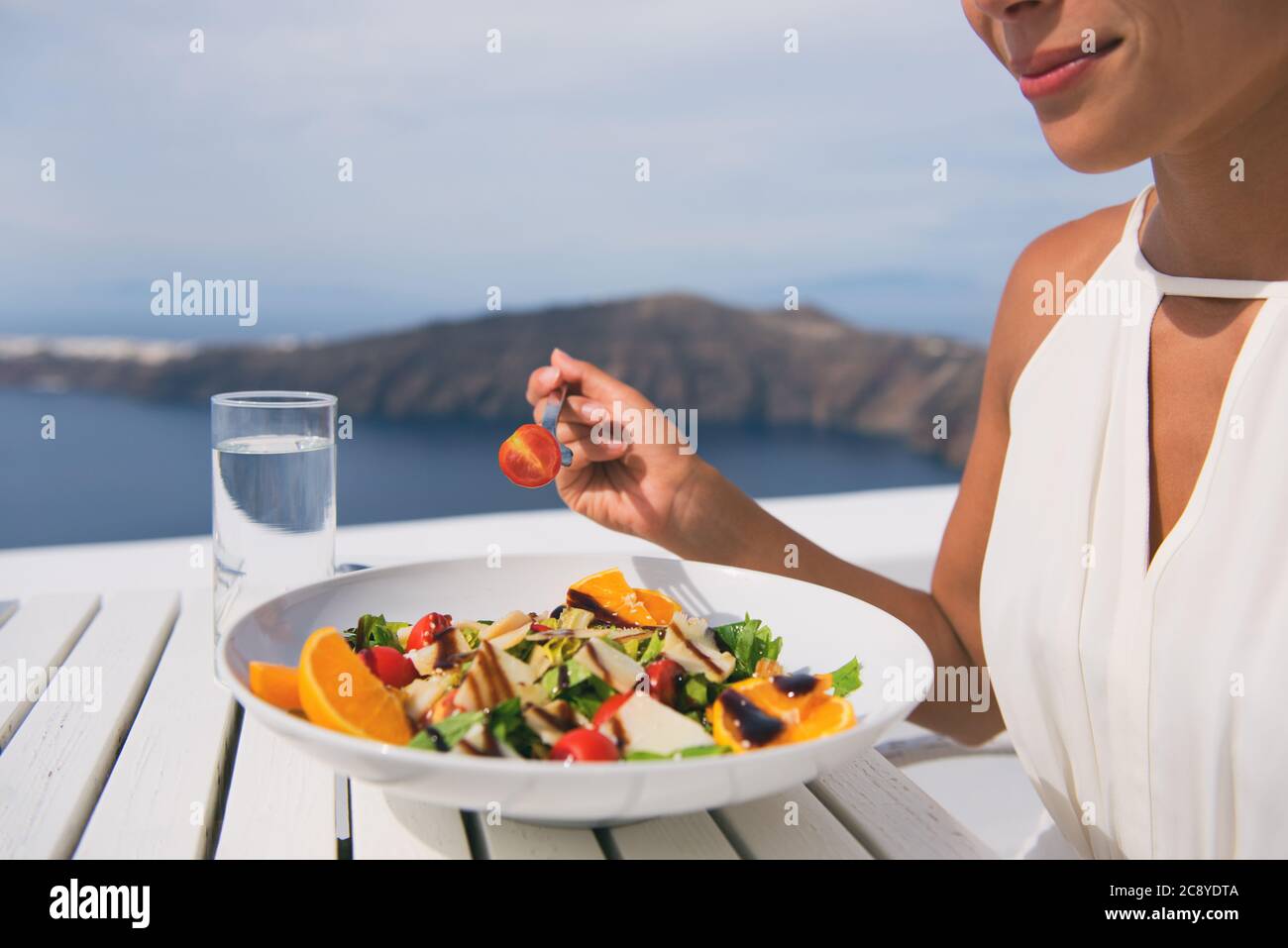 Restaurant woman eating salad luxury europe travel Santorini vacation. Healthy lifestyle people relaxing on Greece holidays Stock Photo