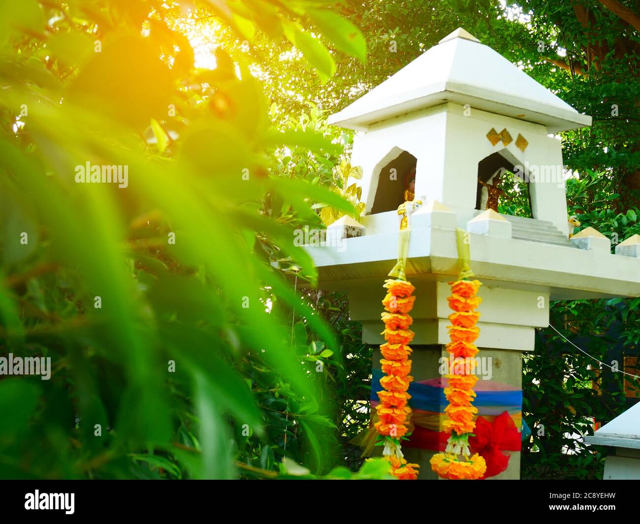 Modern design white shrine of god , Spirit house green leaf and sunrise background, east asia culture, thailand Stock Photo