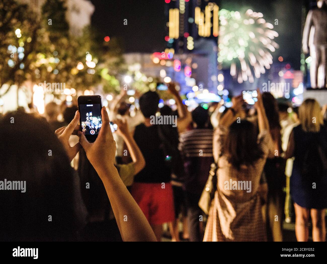 People taking pictures of fireworks with their phones, Ho Chi Minh City, Vietnam Stock Photo