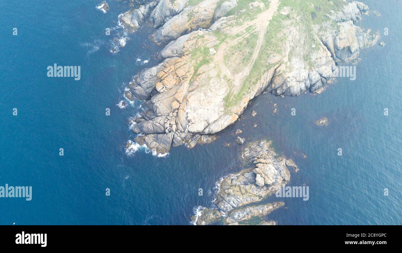 Aerial view of Cliffs and colorful landscape near the sea. reefs reminiscent of the continents of the world. The weather is foggy Stock Photo