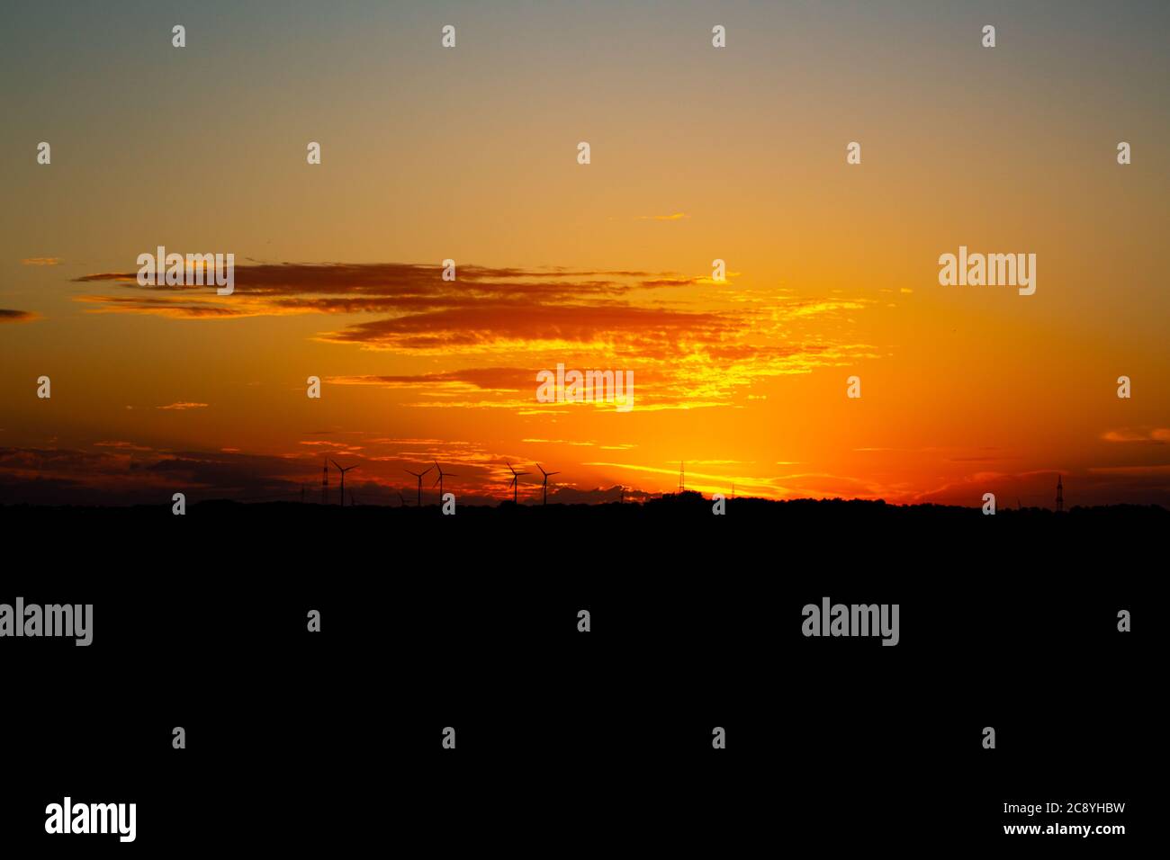Sunrise with silhouettes of wind turbines on the horizon Stock Photo ...