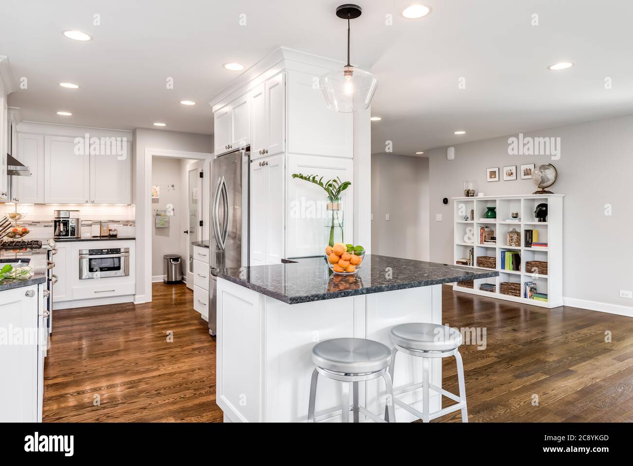 A white modern kitchen with stainless steel appliances and black ...