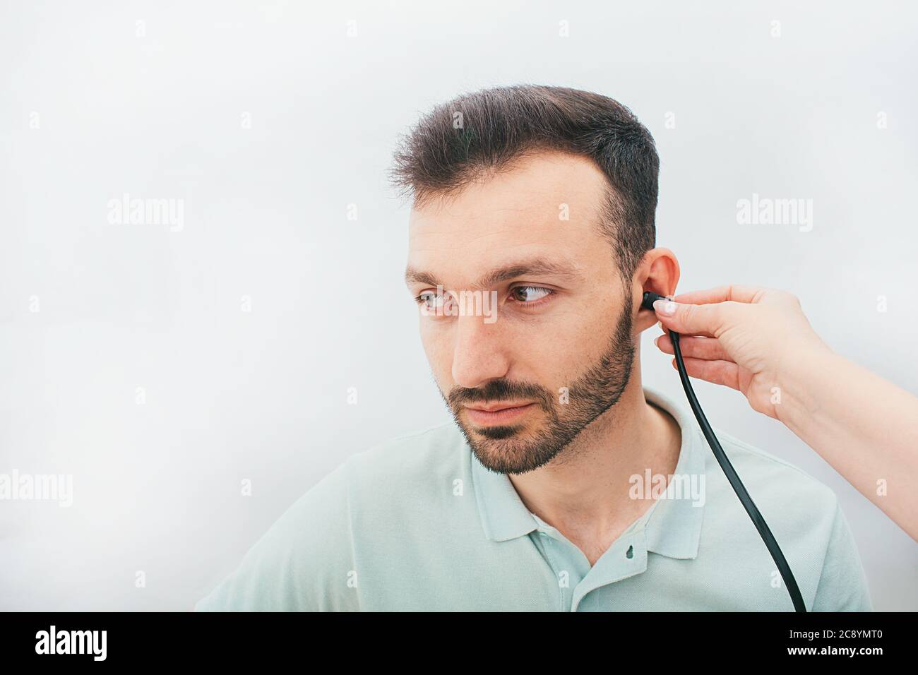 Mixed race man having a hearing test with special medical equipment. Impedance audiometry, tympanometry in a hearing center Stock Photo
