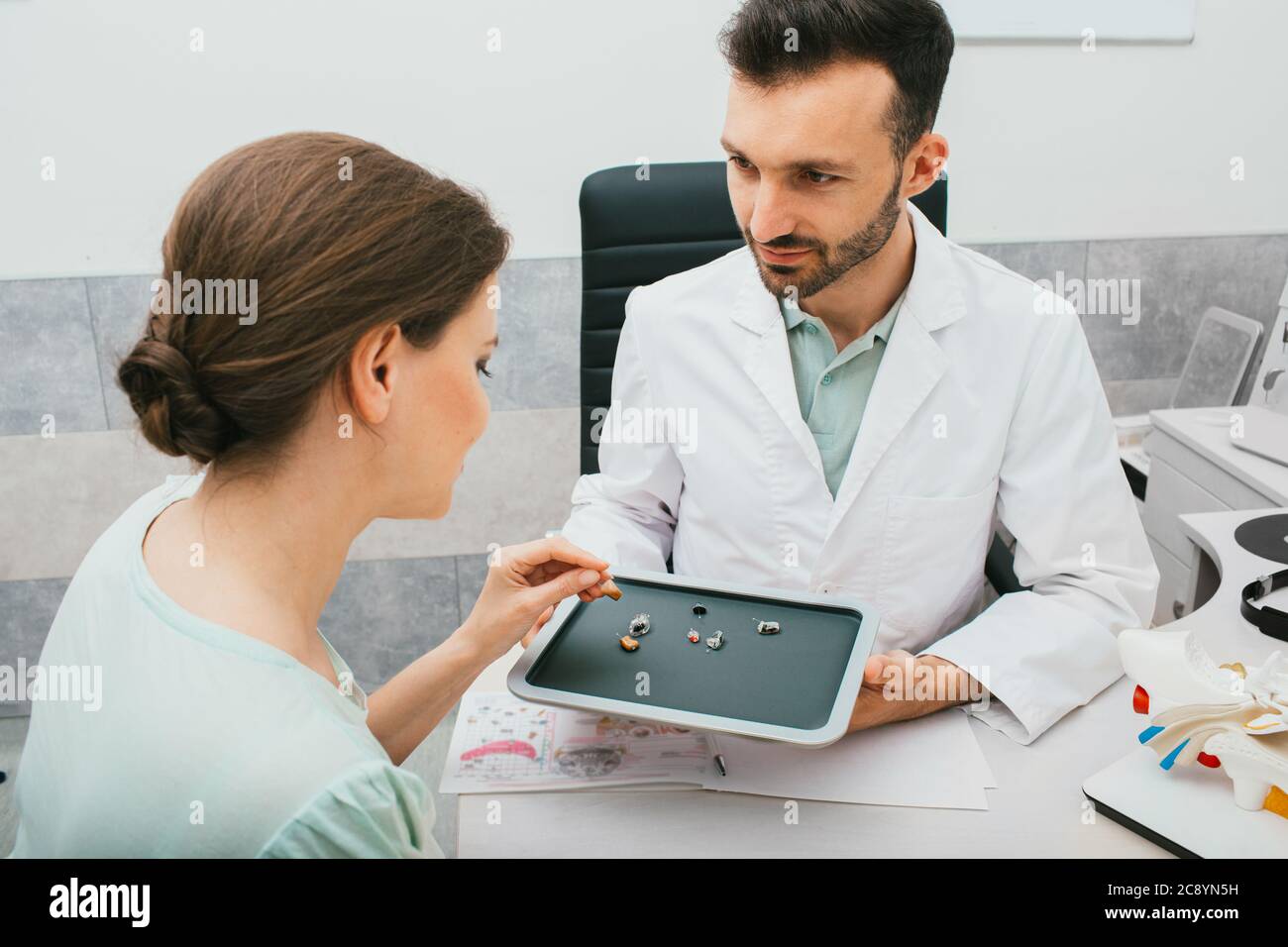 Hearing solution for adults. Audiologist chooses a hearing aid for a caucasian woman. patient needs good hearing aids so that she can hear the sounds Stock Photo