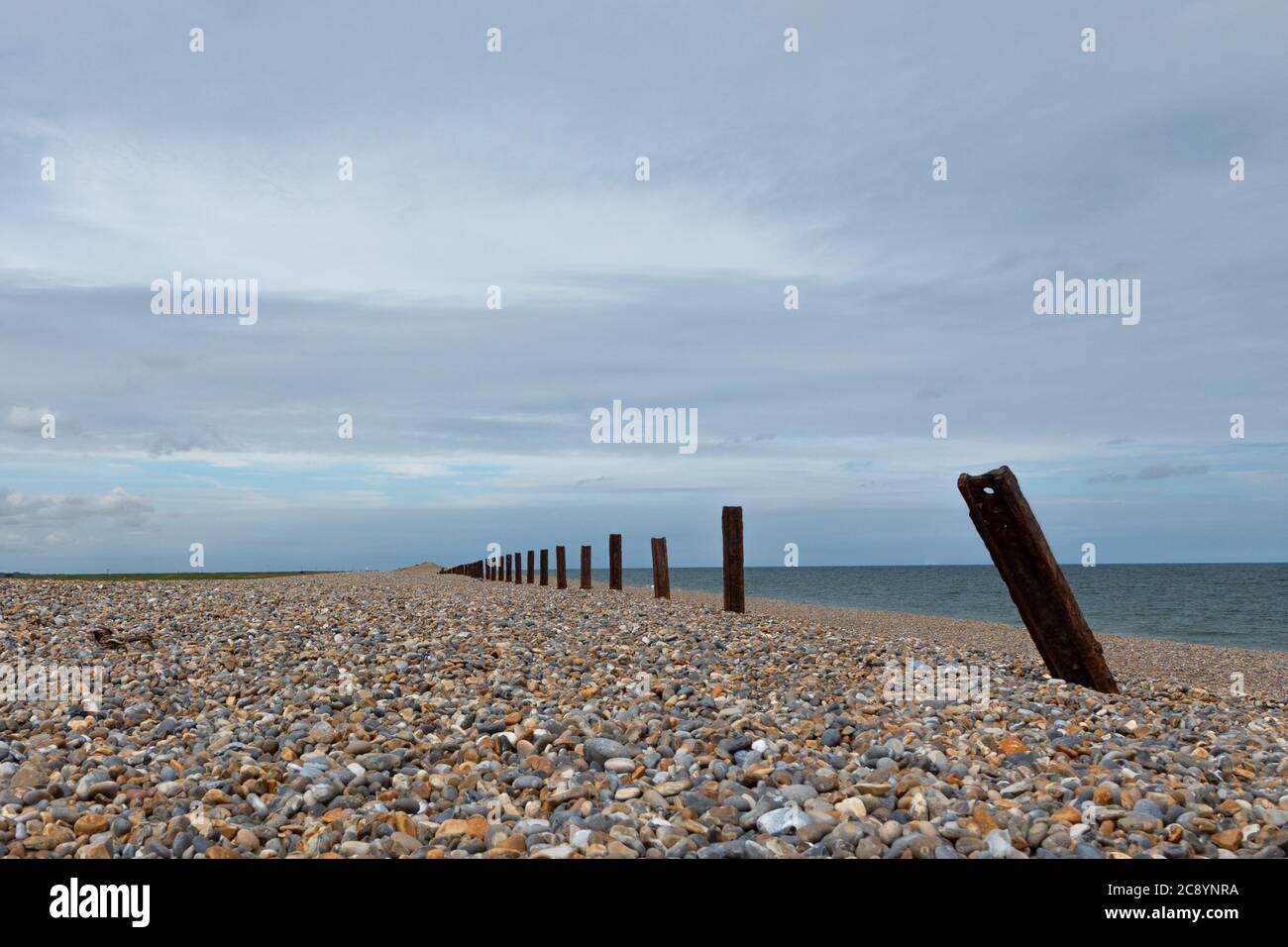 The remains of sea defences rust on the shingle beach at Cley-Next-The sea, Norfolk, England,UK Stock Photo