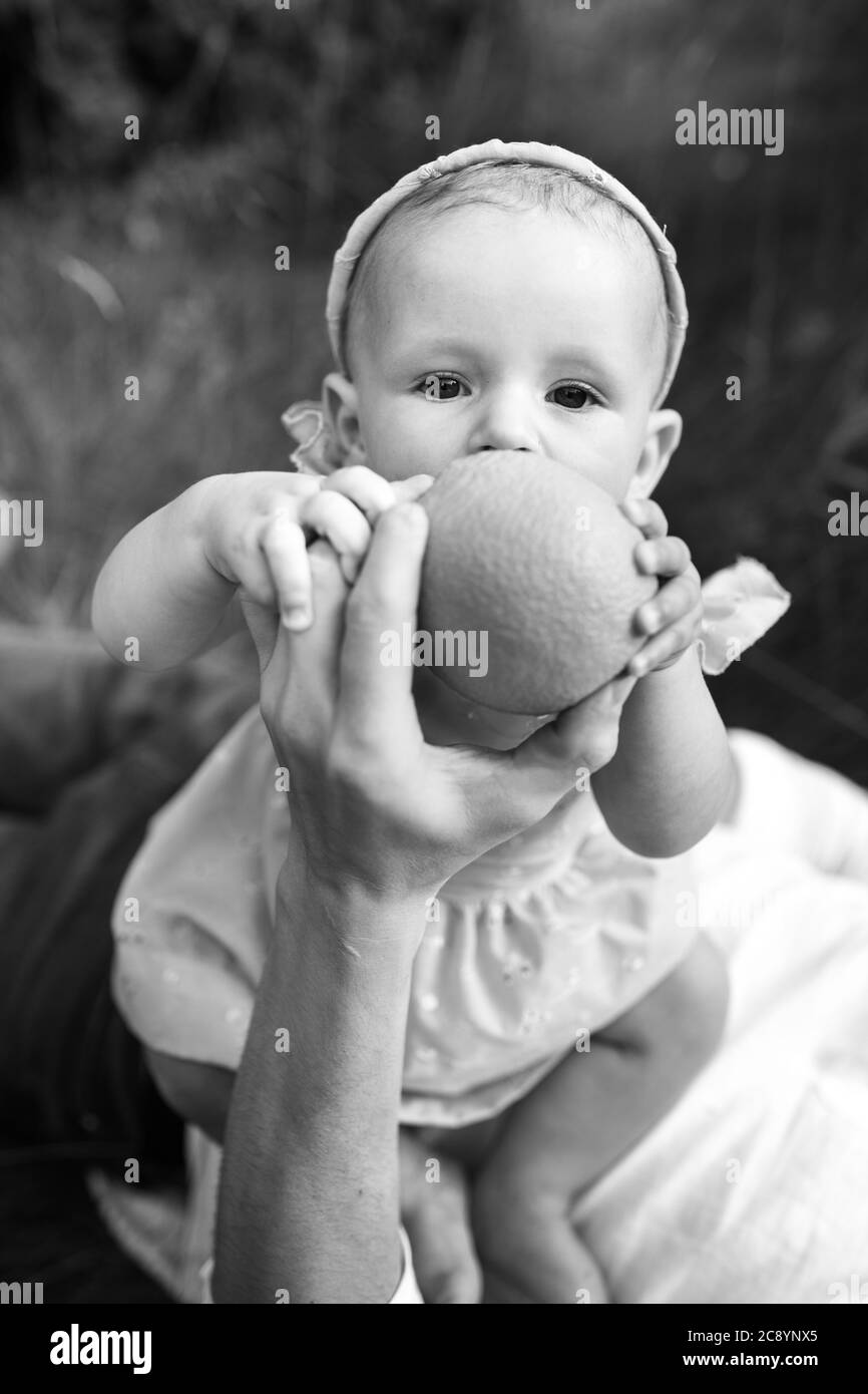 Cute baby girl in blue dress with family having a picnic in the park