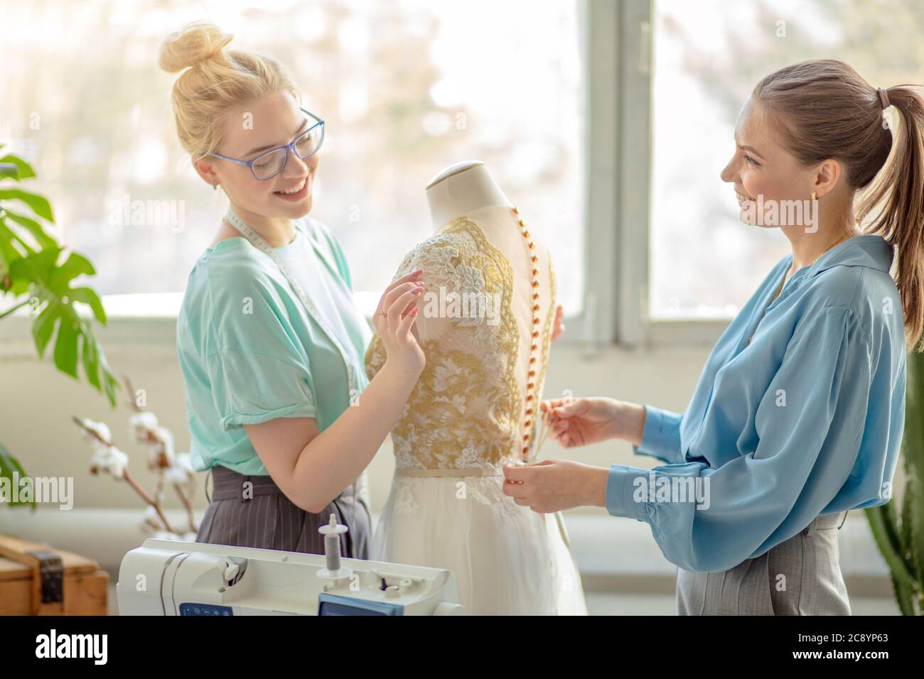 Two female fashion designers working together at workplace at