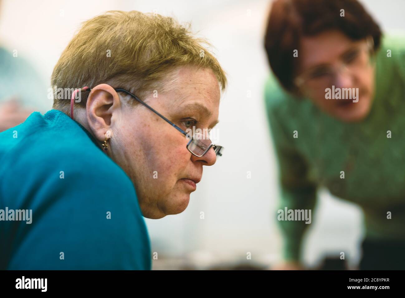 An elderly woman in the company of a friend enthusiastically examines something Stock Photo