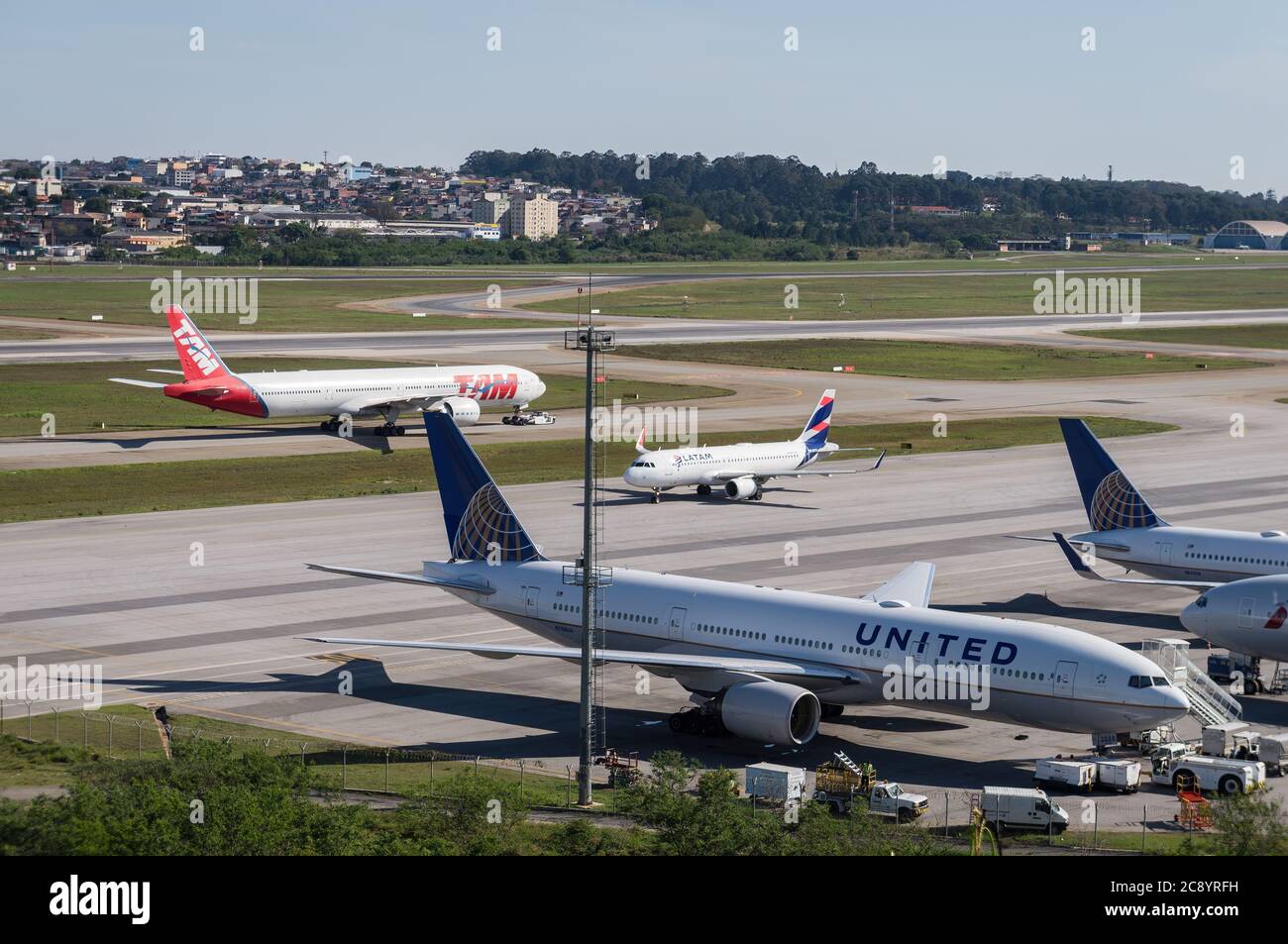 Ground traffic crossing each other in front of the remote parking area of Sao Paulo/Guarulhos Intl. Airport. View from Morrinho spotting location. Stock Photo