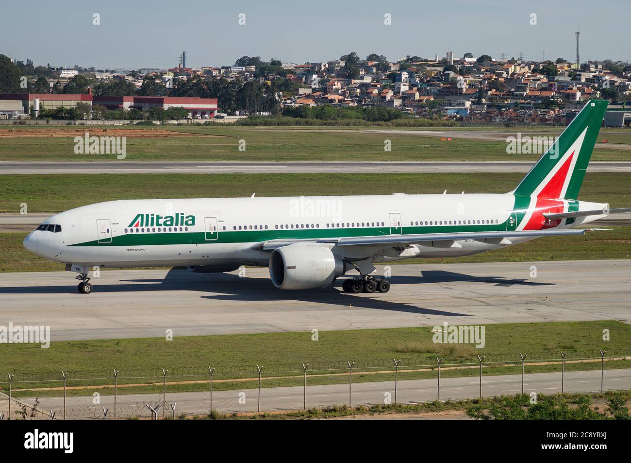Alitalia Boeing 777-243ER (EI-ISB - named 'Porto Rotondo' - widebody aircraft) taxing heading runway 27R of Sao Paulo/Guarulhos International Airport. Stock Photo