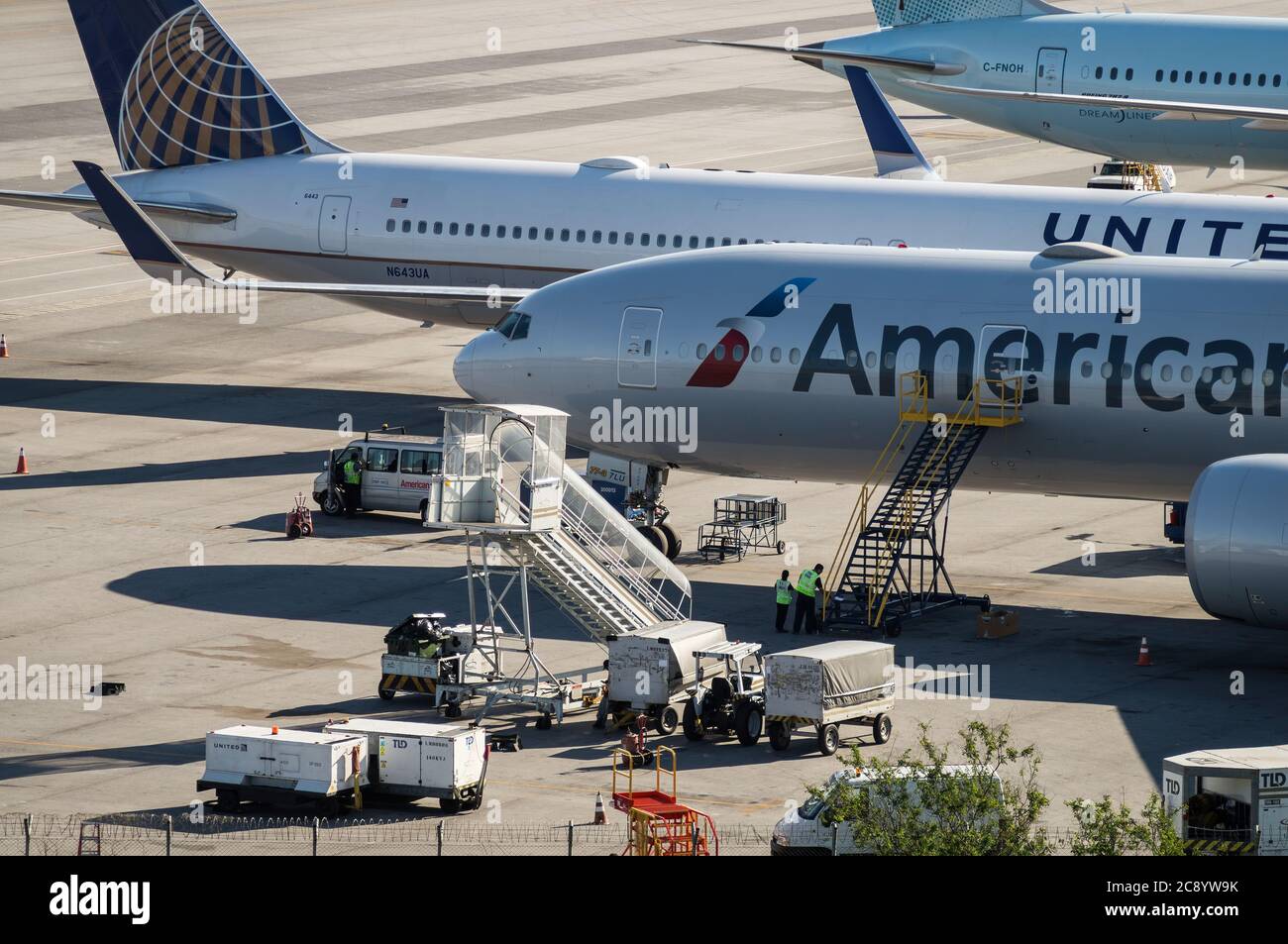 Boeing aircrafts serviced by ground handling crews awaiting the next scheduled flight while on the remote area of Sao Paulo/Guarulhos Intl. Airport. Stock Photo