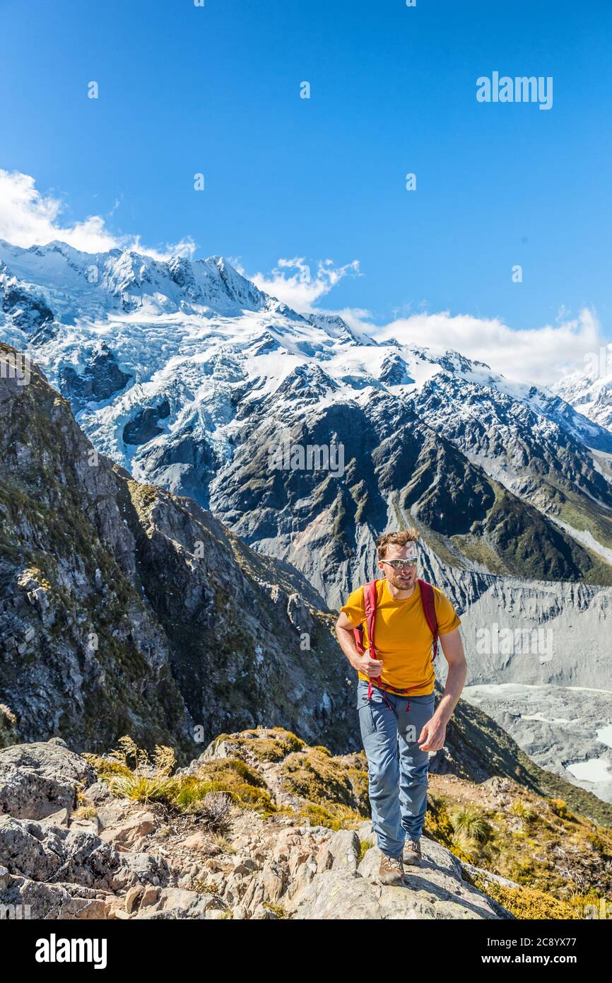 Hiking hiker man tramping in New Zealand mountains. Alpine trekking lifestyle mountaineering excursion with snow capped mountains landscape Stock Photo
