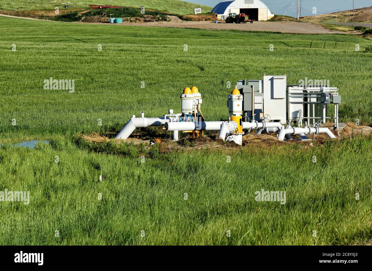 Three agricultural water pumps at a pumping station to bring water up from a well for irrigation in an Idaho Farm field. Stock Photo