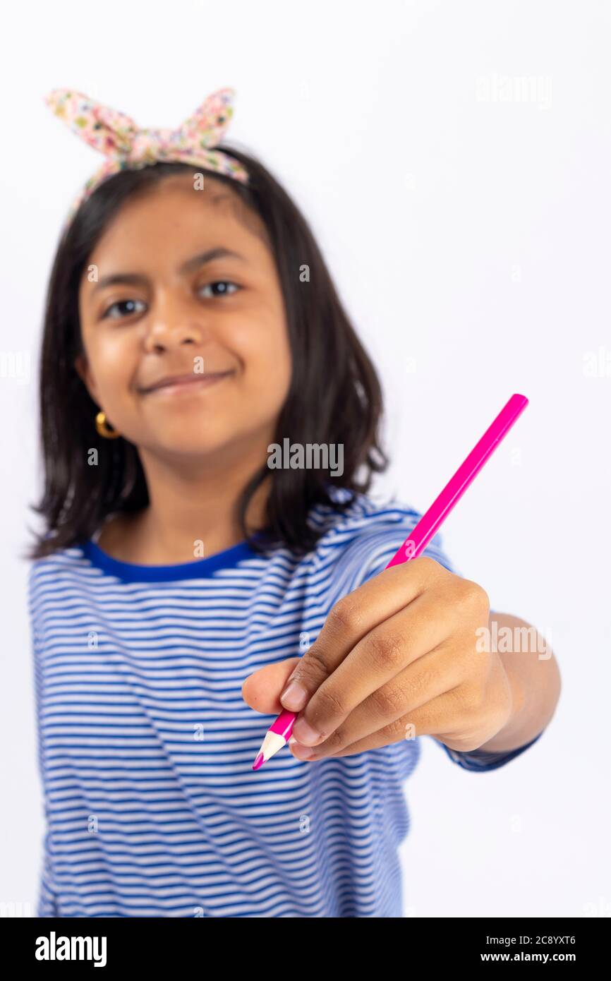 Cute left-handed girl is writing with a pencil in her notebook. Stock Photo