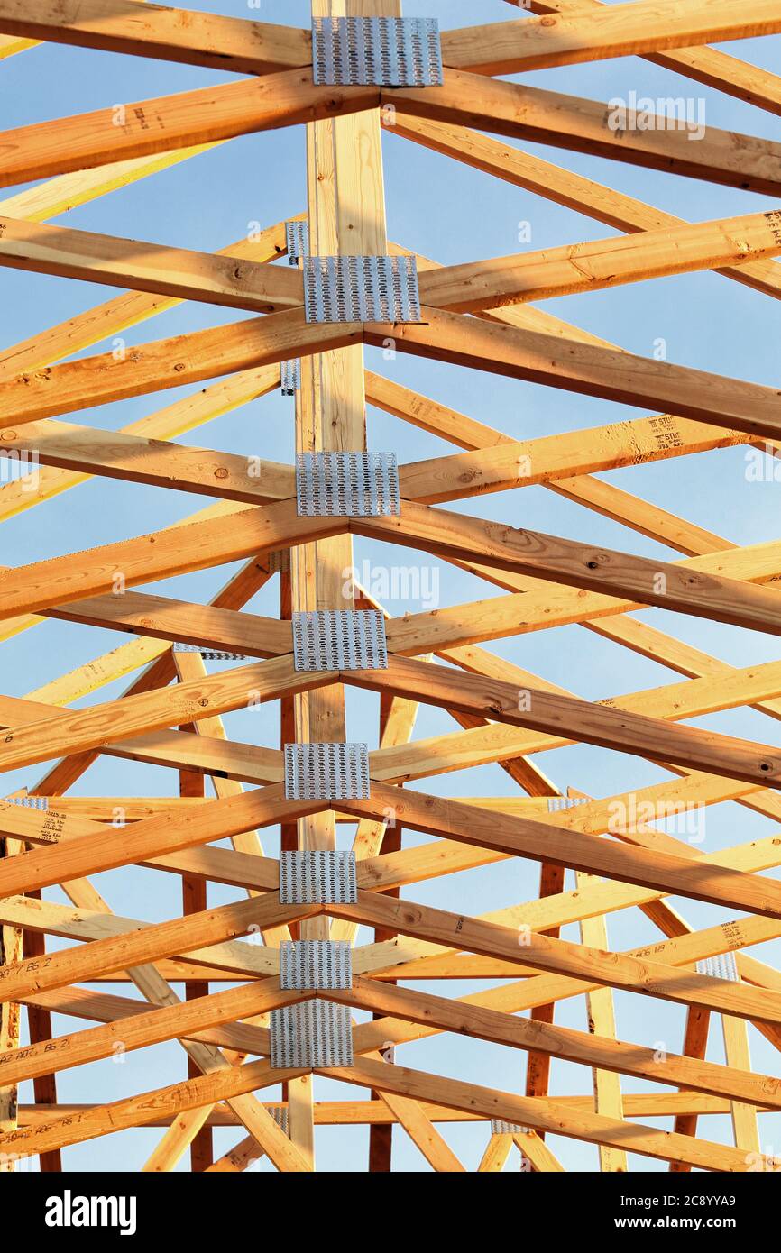 A stickbuilt residential building, with fir roof trusses and oriented strand board sheathing, under construction. Stock Photo