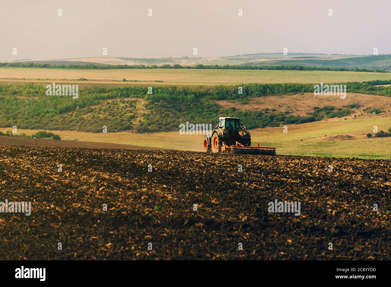 Photo of tractor cultivating a land, preparation for new year Stock