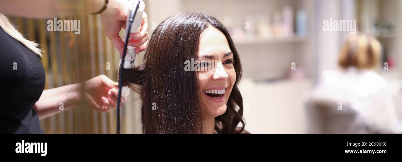 Hair stylist using curling iron Stock Photo
