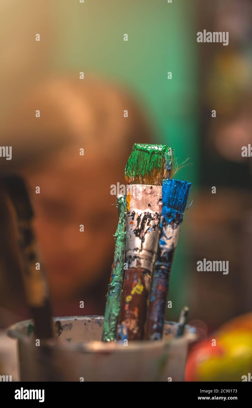 Used paintbrushes with dried paint left standing in a cup Stock Photo