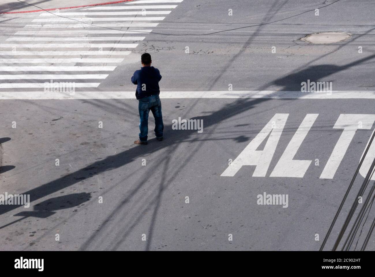 Caregiver of cars in Latin American street, stop sign painted on the asphalt in urban area. Stock Photo