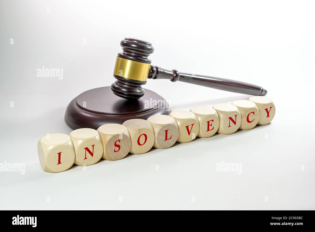 Judge gavel and wooden dices with the word Insolvency, some companies have to close after the coronavirus crisis, gray background with copy space, sel Stock Photo