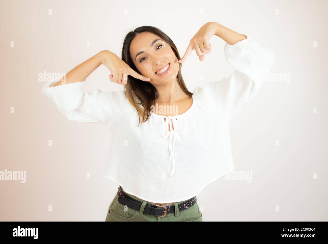 Beautiful young woman in white shirt gesturing Stock Photo - Alamy