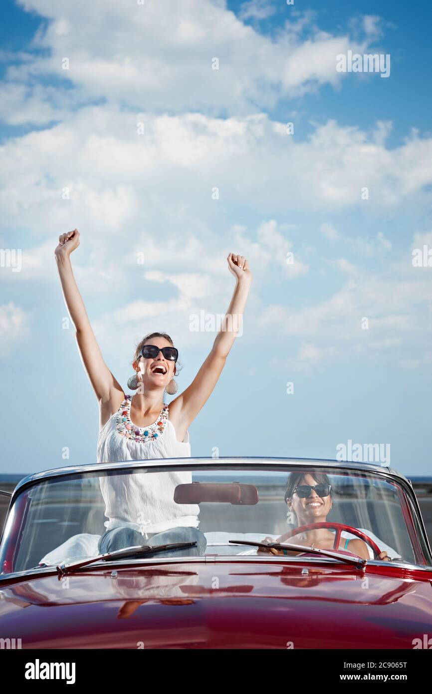 Happy Women Driving Rented Convertible Car For Vacations Stock Photo