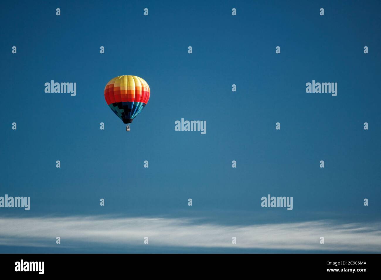 An aerial view of a hot air balloon against a blue sky, floating over the Idaho country side. Stock Photo