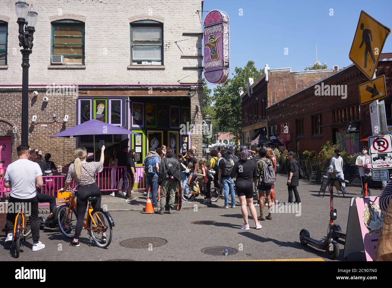 A group of BLM protesters demonstrate outside the Voodoo Donuts shop as they march along the 3rd Ave towards the federal courthouse in Portland, Oregon. Stock Photo