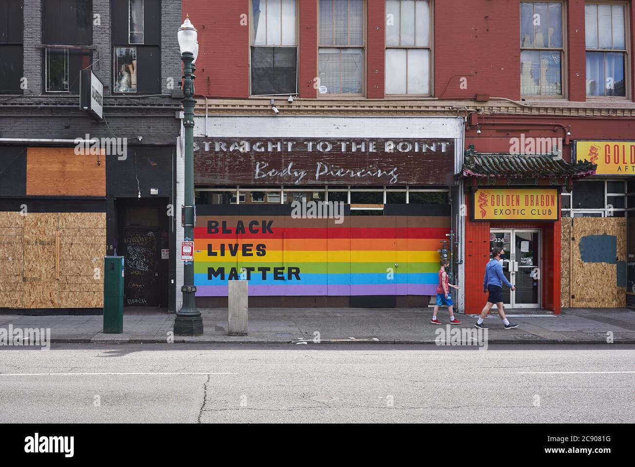 Black Lives Matter sign on the Rainbow Flag seen at the boarded-up storefront of a local business in downtown Portland, Ore., on Saturday, 7/11/2020. Stock Photo