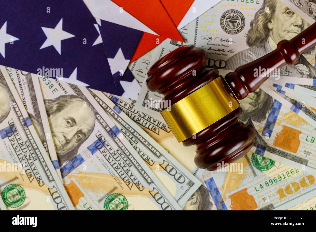 Wooden judge hammer on american flag of office Justice and law on us dollar currency american cash Stock Photo