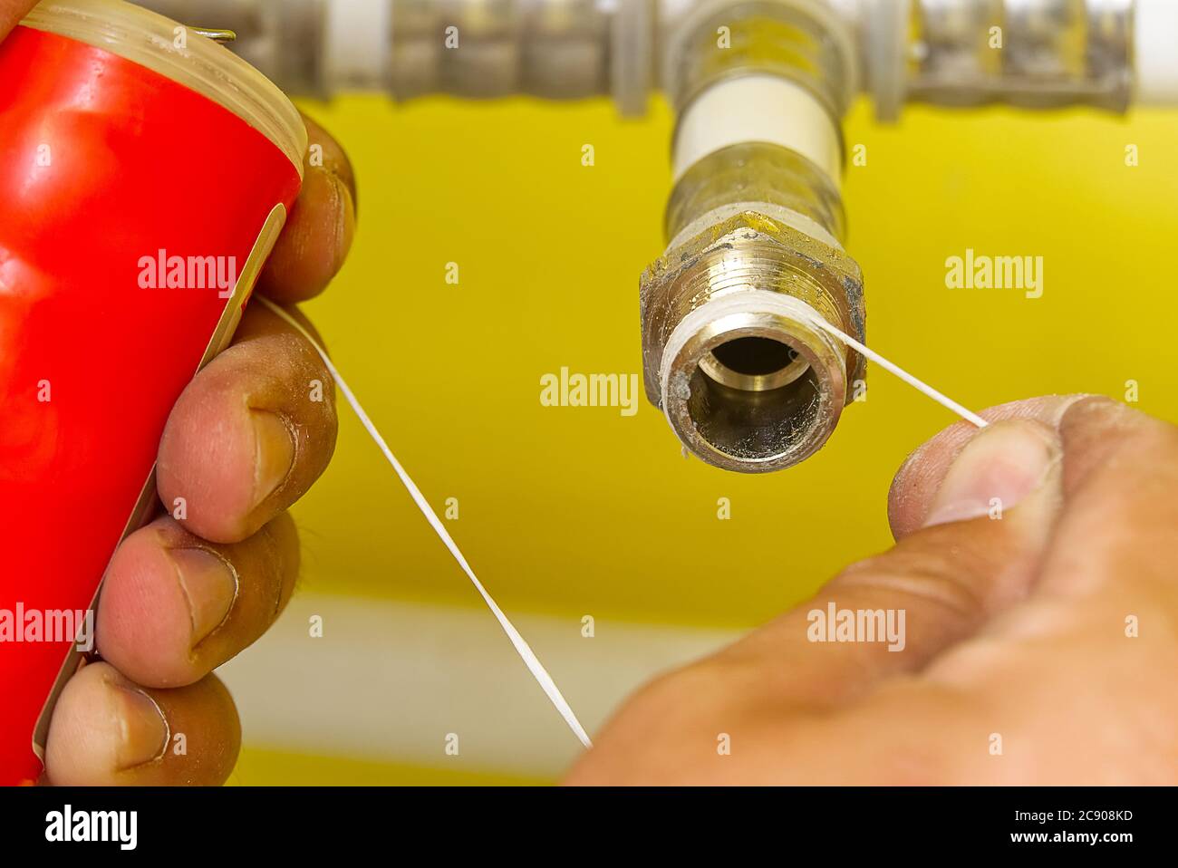 Worker installing sealing tape for water pipe fitting.Plumber putting