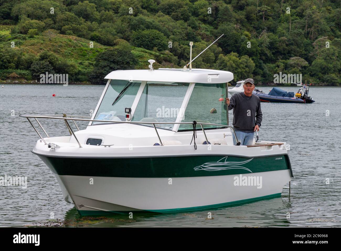 Male 30-50 onboard a Beneteau Antares 600 motor boat. Stock Photo