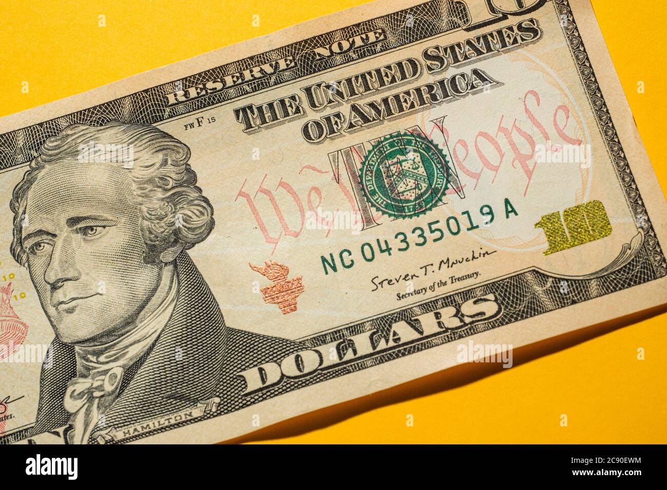 Close-up of US ten dollar bill on yellow Stock Photo