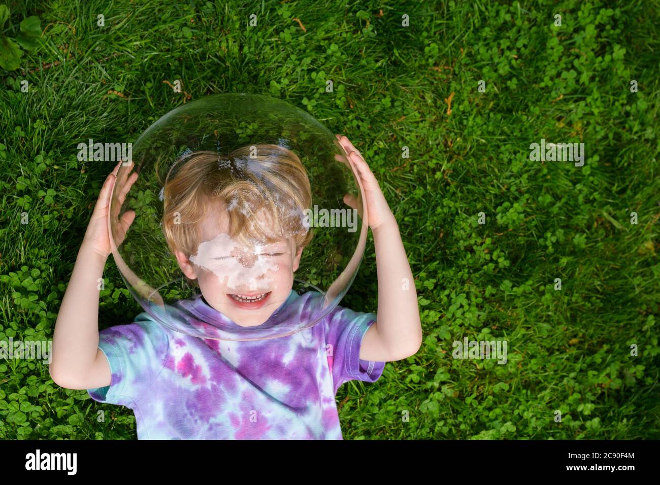 Boy wearing bubble outdoors to socially distance Stock Photo
