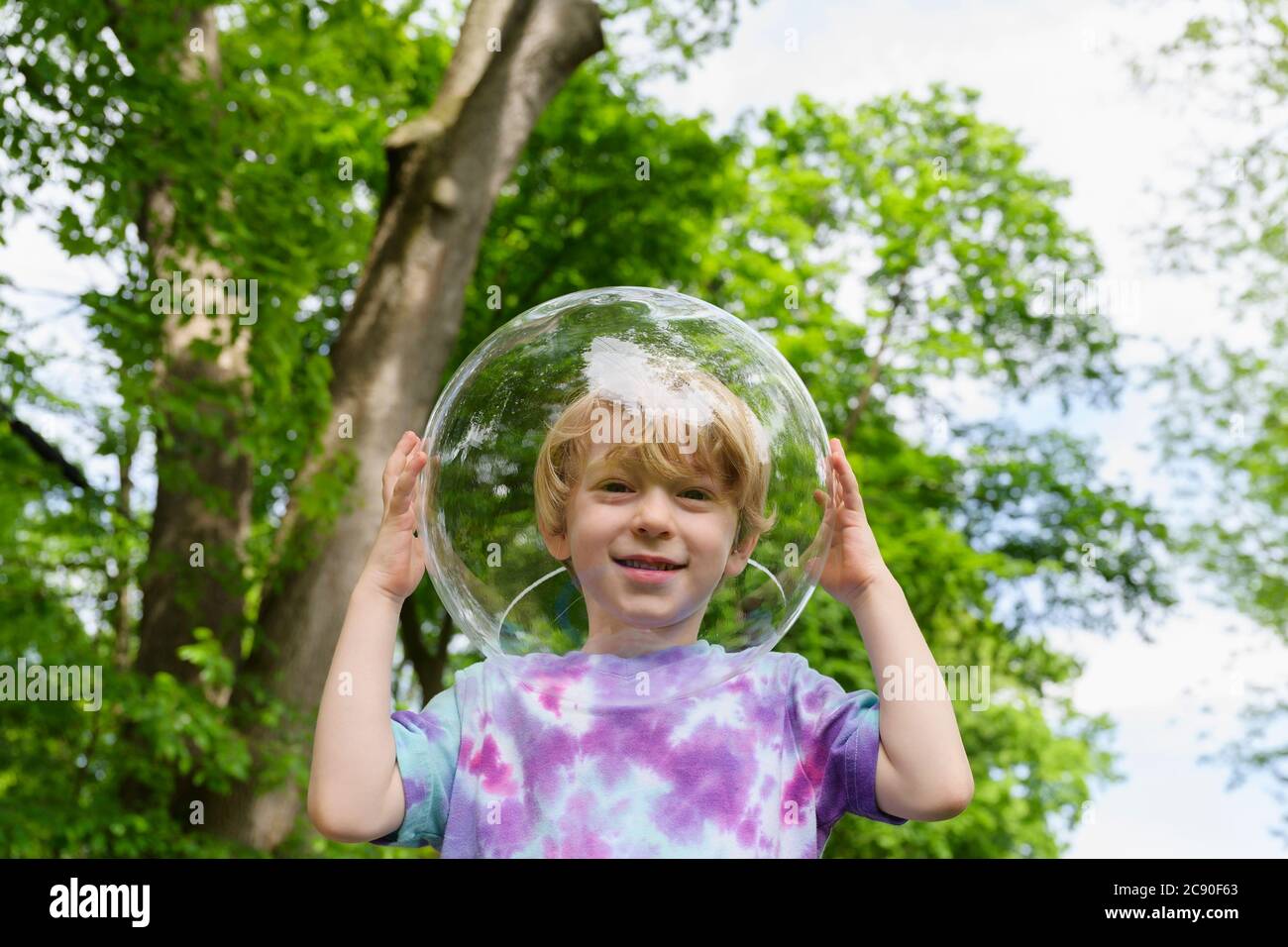Boy wearing bubble outdoors to socially distance Stock Photo