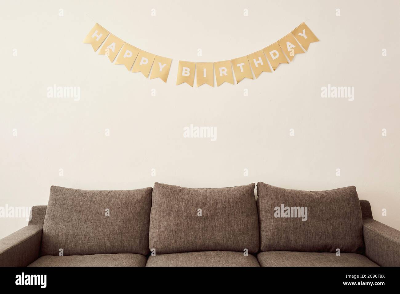 Happy birthday wishes on wall above sofa Stock Photo