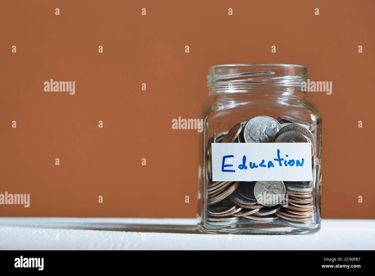 Coins in jar collected for education Stock Photo