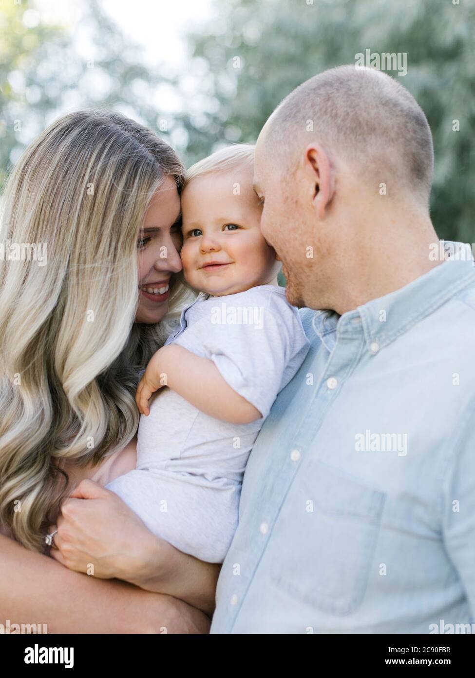 Parents kissing baby boy son Stock Photo