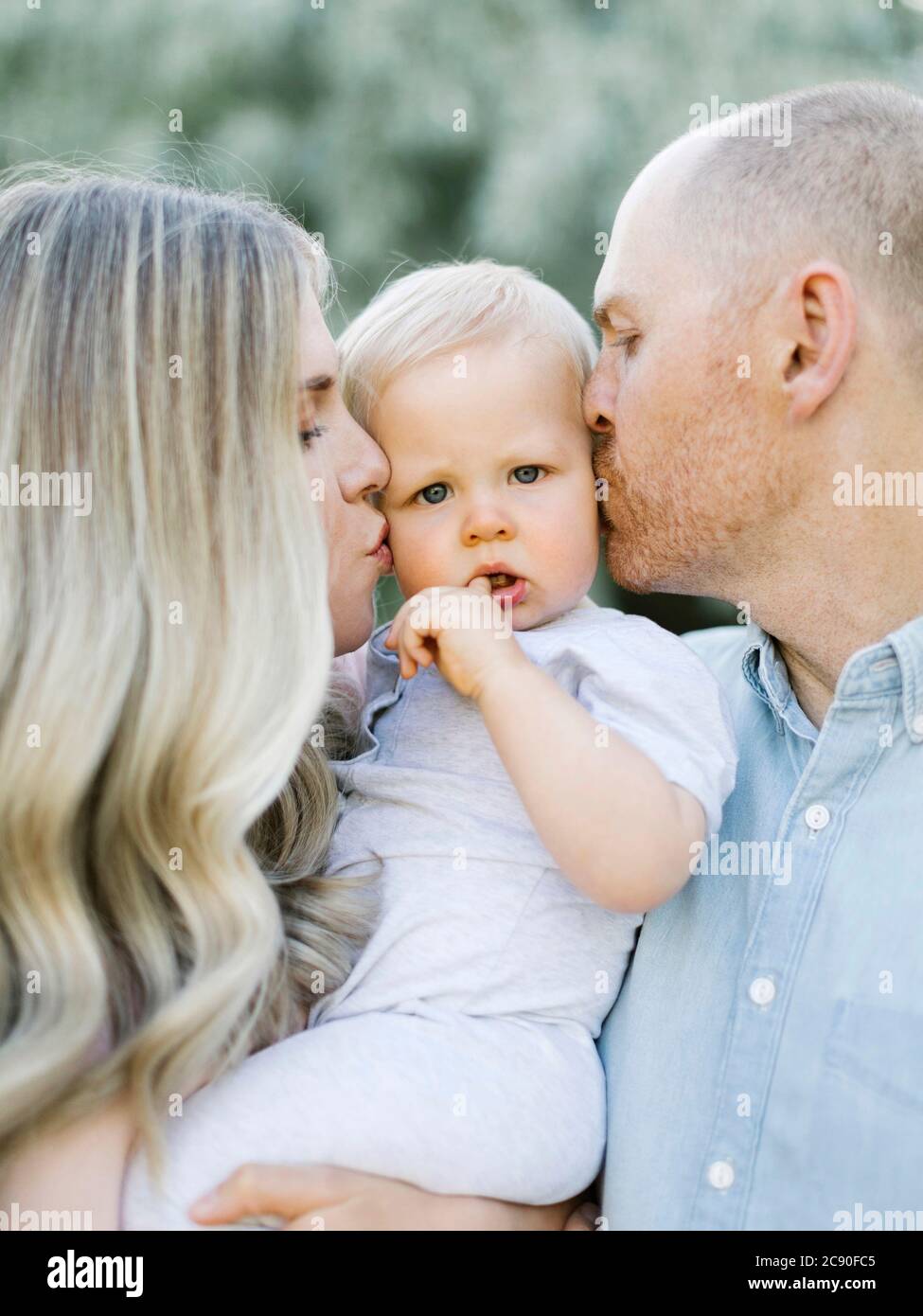 Parents kissing baby boy son Stock Photo