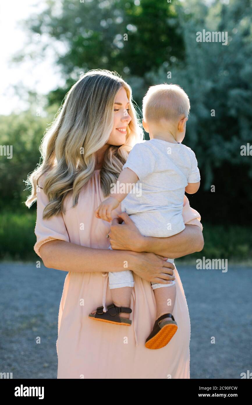 Mother carrying baby son outdoors Stock Photo