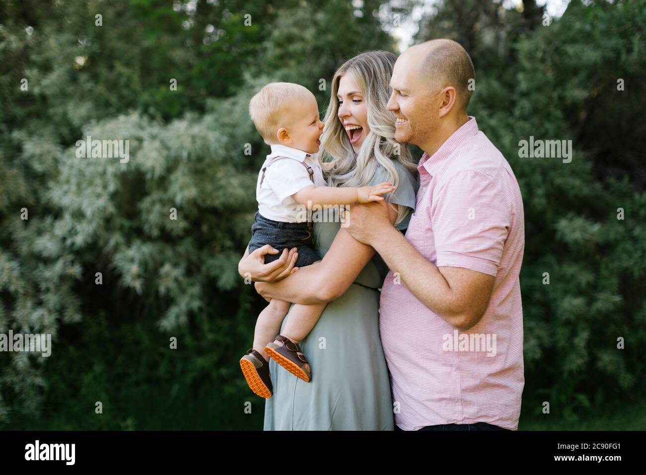 Parents embracing with baby son outdoors Stock Photo