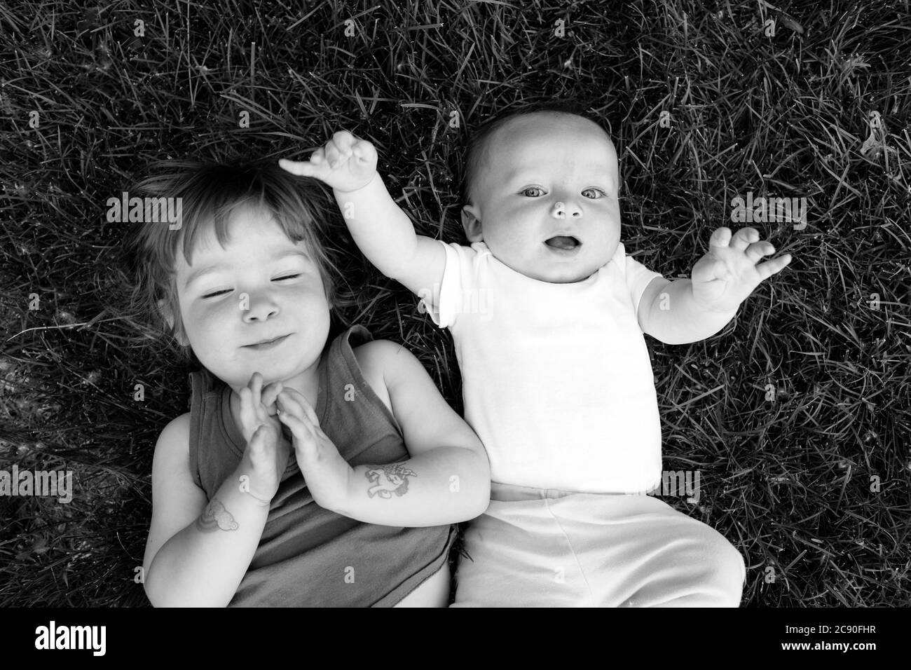Portrait of siblings lying in grass Stock Photo