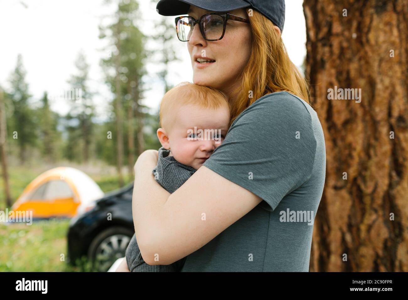 USA, Utah, Uninta Wasatch Cache National Forest, Woman holding baby son (6-11 months) during camping Stock Photo