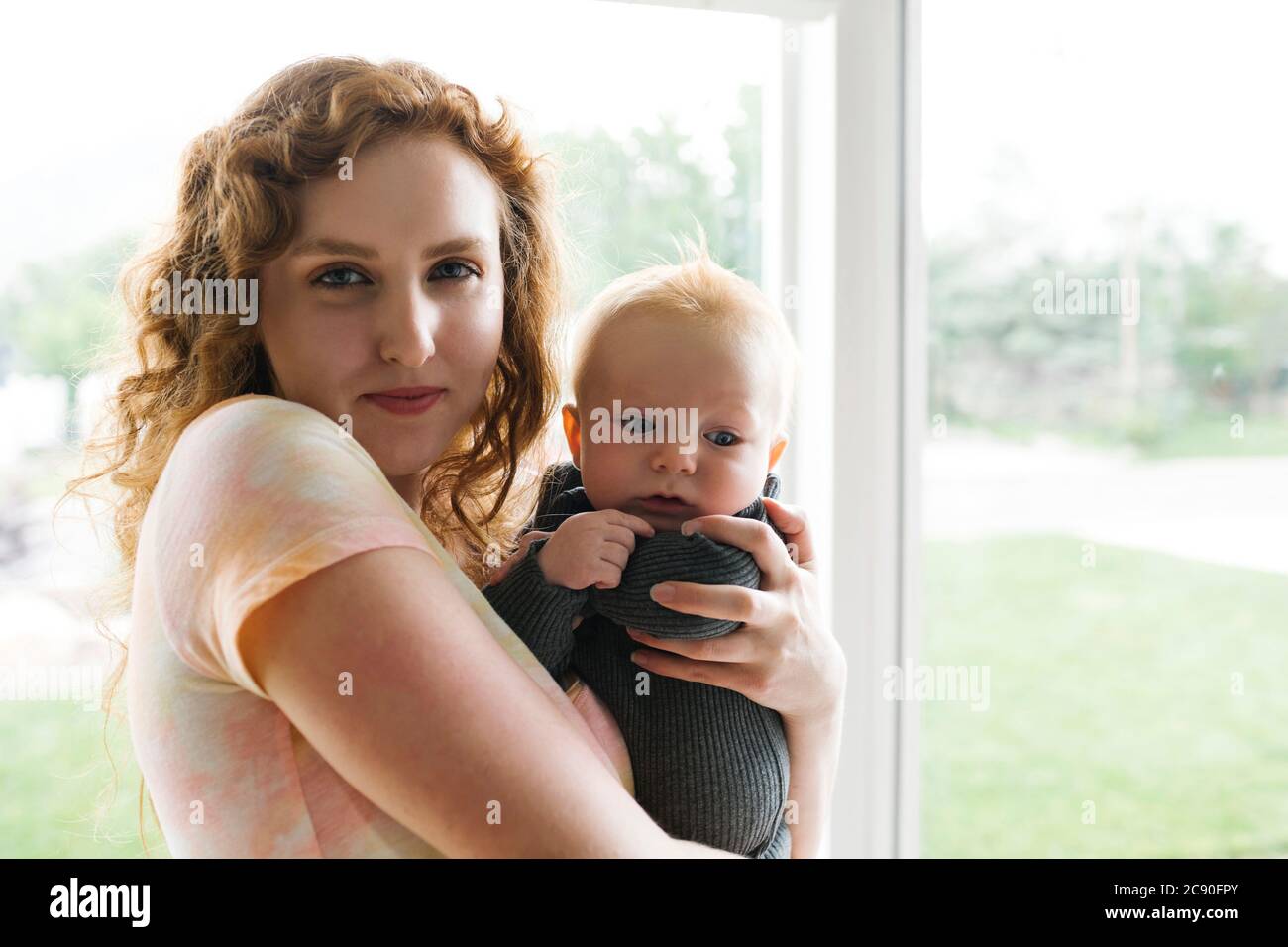 Portrait of woman holding baby son (6-11 months) Stock Photo