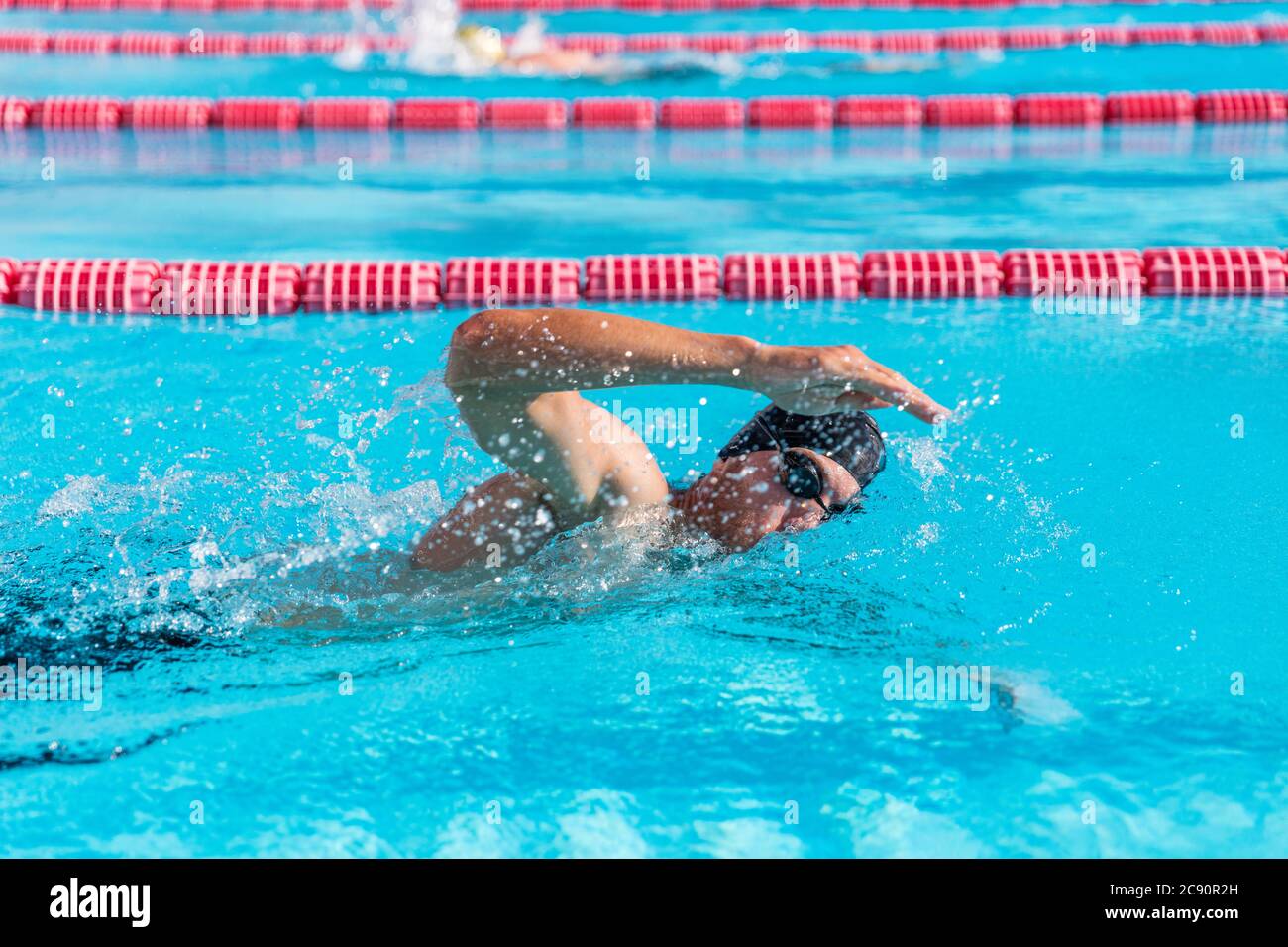 Swimmer man fitness training at swimming pool. Professional male athlete doing crawl freestyle stroke technique Stock Photo
