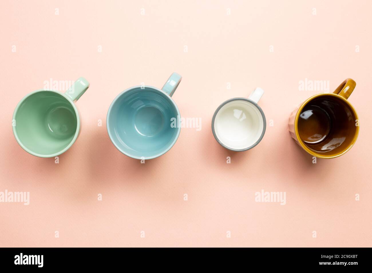 Colorful empty mug cups on pink background. top view Stock Photo